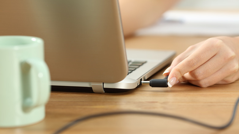person charging their laptop