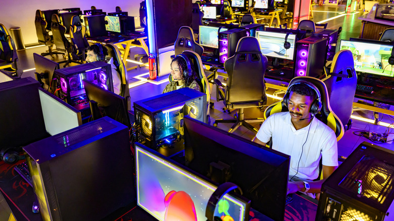 Photo of a number of people at brightly lit gaming PC setups