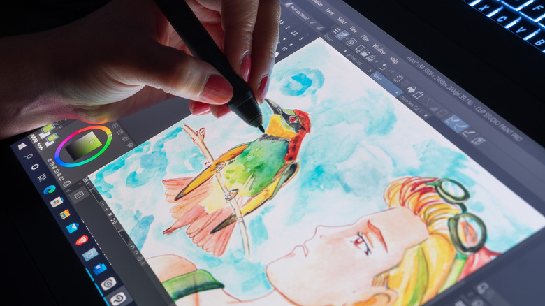 a person drawing on a Wacom tablet