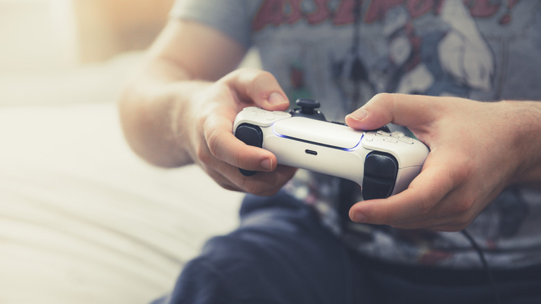 A person playing a PlayStation 5 game with a DualSense controller