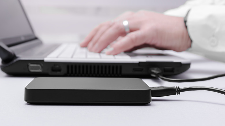 a sideview of a person using an external hard drive