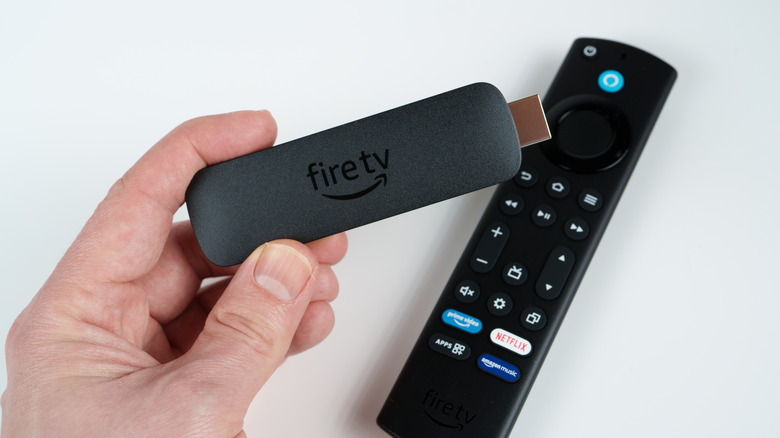 A person holding an Amazon Fire TV Stick.