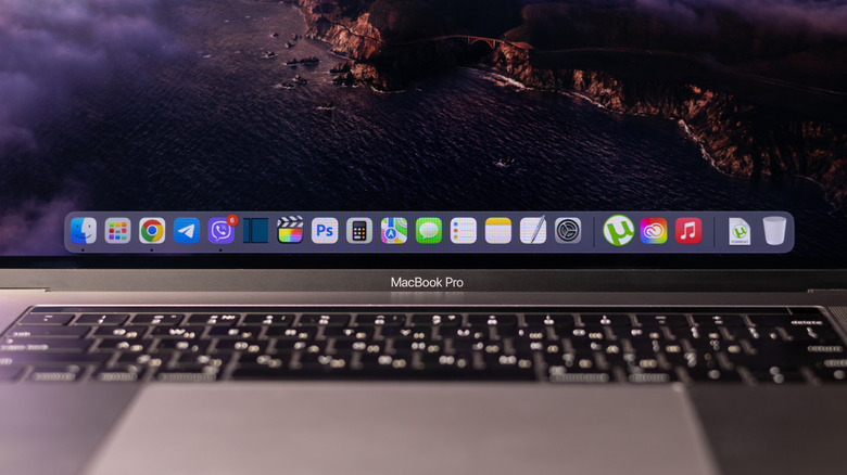 A MacBook Pro opened and displaying a Dock full of apps.