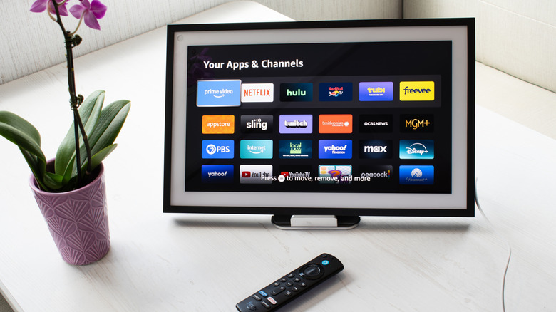 An Alexa device with a display screen on a table near a remote
