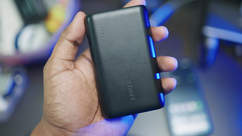A hand holding an Anker power bank.