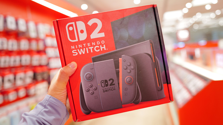 A person holding a packaged Nintendo Switch 2 box