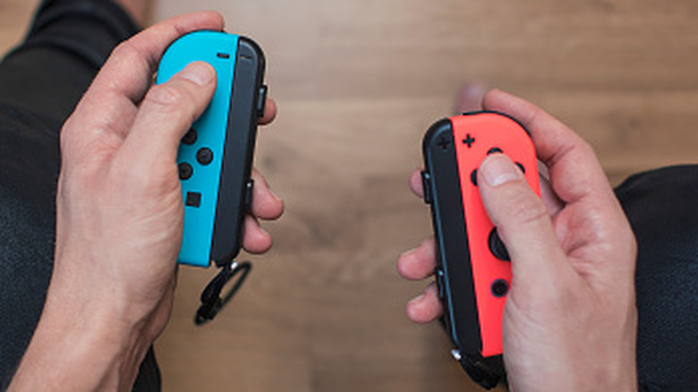 Blue and red colored Switch 2 Joy-Cons being held without the central screen