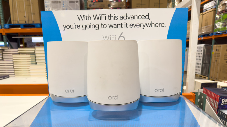 Three Netgear Orbi devices on display at a department store.