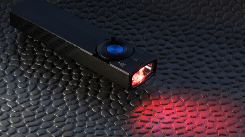 A small rectangular red light flashlight