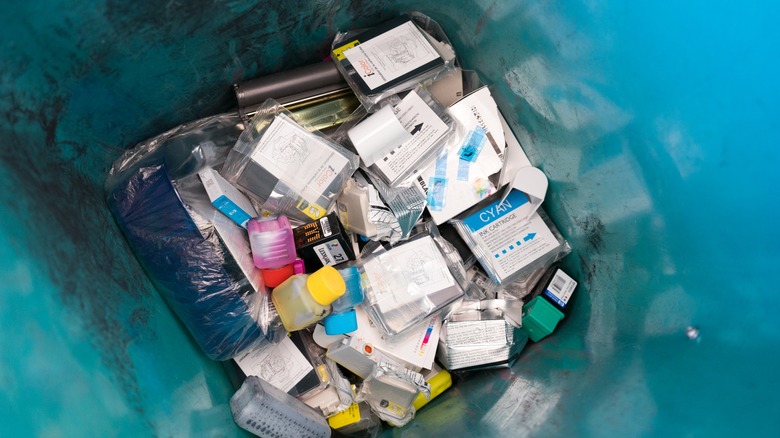 Old printer cartridges collected in a bin.