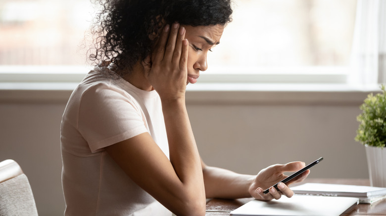 a woman looking frustrated at her phone