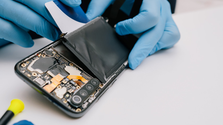 A person replacing the battery of an Android phone.