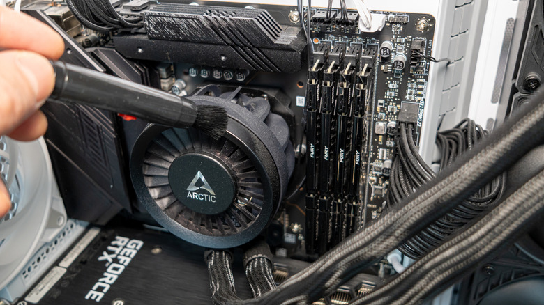 A technician cleans out an all-in-one PC cooler.