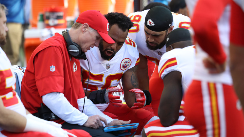 Kansas City Chiefs players and coach looking at a tablet