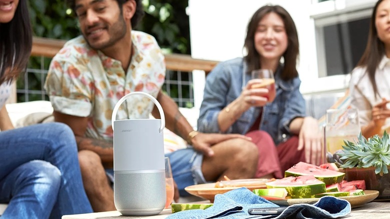 Bose Portable Smart Speaker on table around group of friends