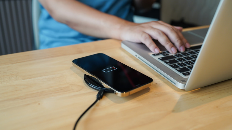 Close-Up of a wireless charger on a person's desk with a phone placed on it