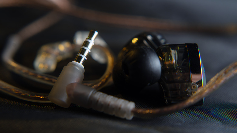 Close-up of 3.5-millimeter audio jack with ear monitors and cabling visible.