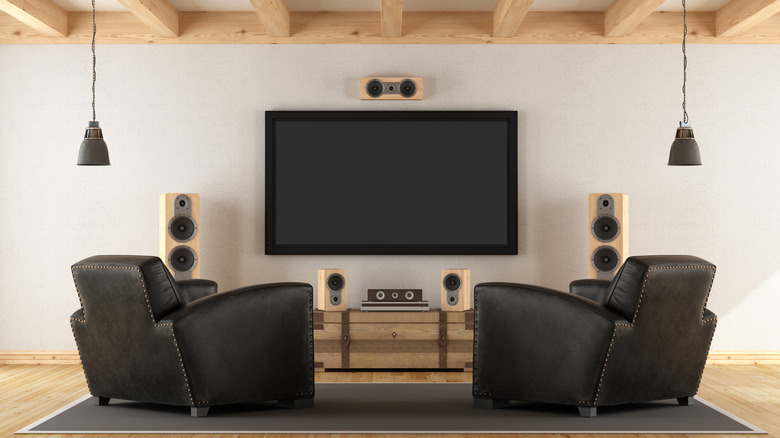 Chairs in front of a home theater setup with speakers and a TV