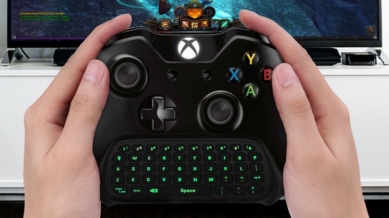 A person holding an Xbox controller with a MoKo keyboard