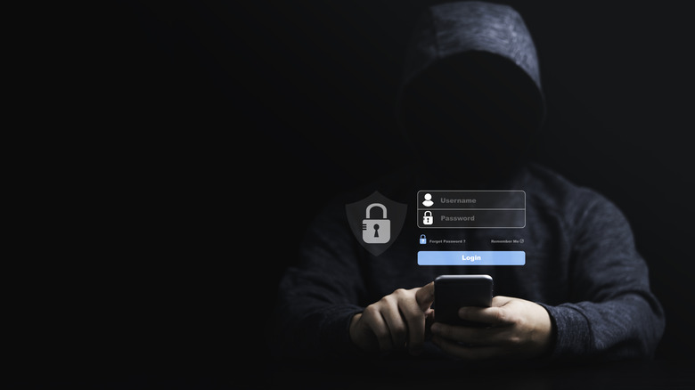 Stranger in black hoodie using mobile to login.