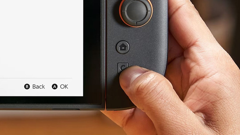 Close-up of a hand pressing Nintendo Switch 2 C button used to open Game Chat features