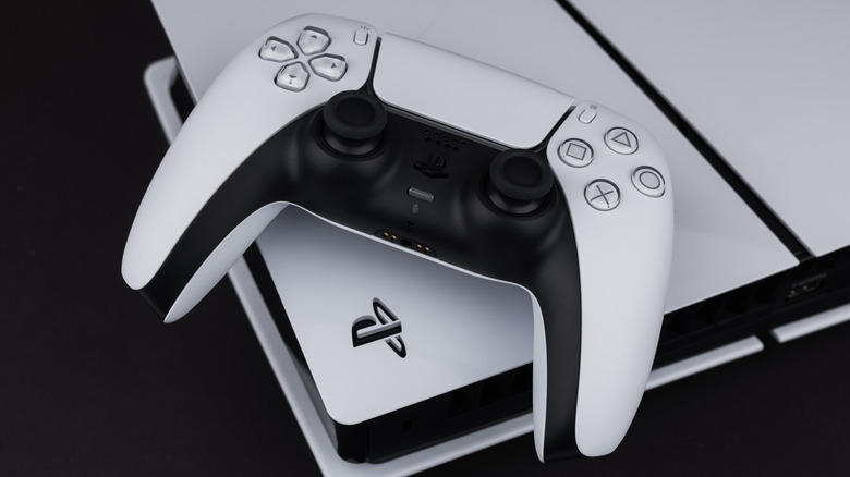 A single black and white DualSense game controller on top of a white PlayStation 5.