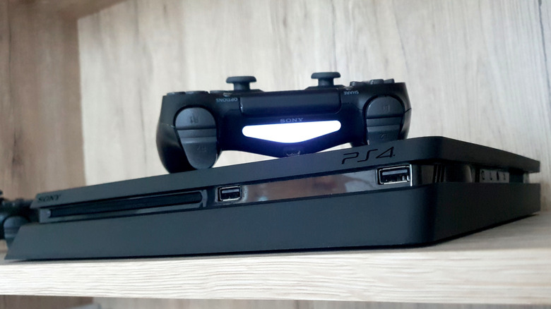 PlayStation 4 on shelf with controller on top