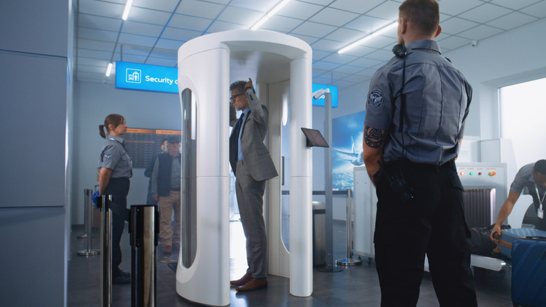 a businessman going through a TSA body scanner