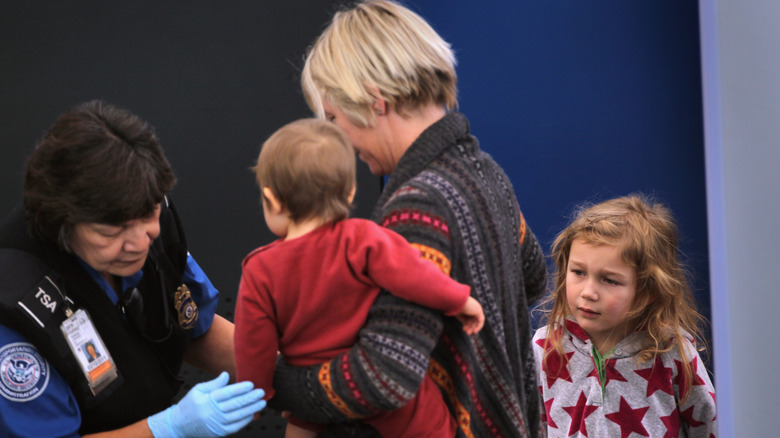 a woman with two children at a TSA security check