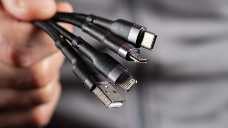 hand holding different types of USB connectors