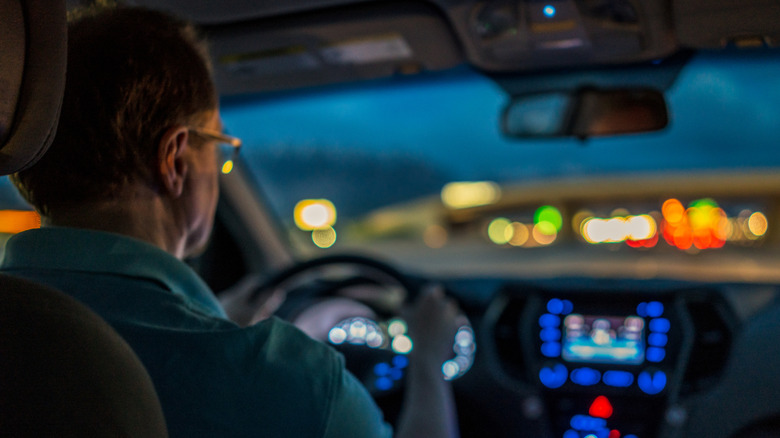 a man driving to work in the dark