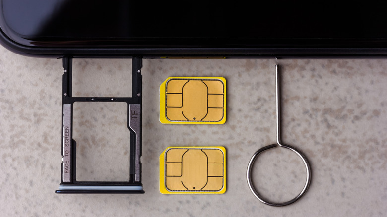 A pair of nano SIM SD cards next to a mobile device