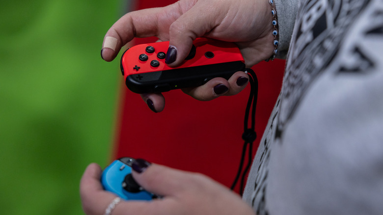 a person holding the Nintendo Switch Joy-Con controller