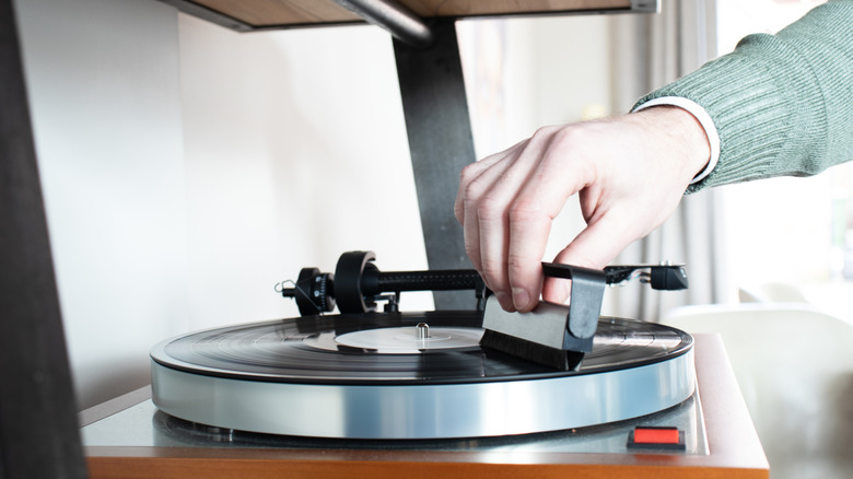 Person using an anti-static brush on a vinyl record