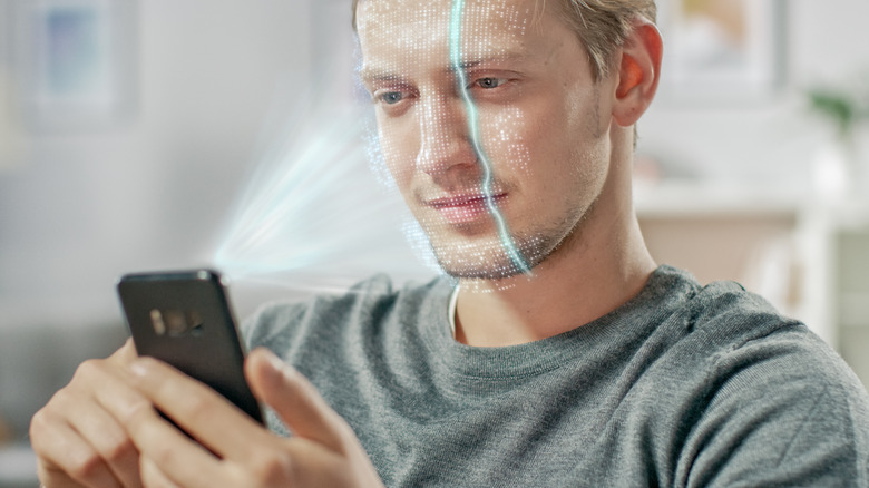 A man using facial recognition on a phone
