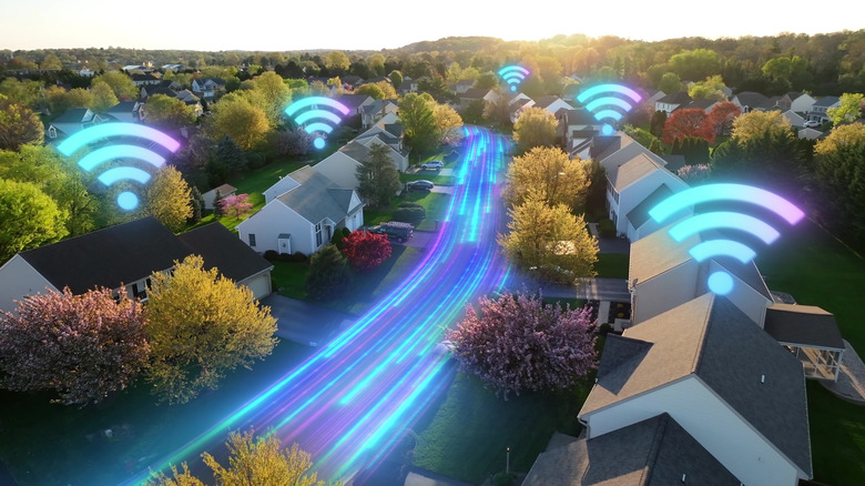 View of a street with various houses having Wi-Fi symbols on top of them and glowing lights passing through the street, representing your internet connection