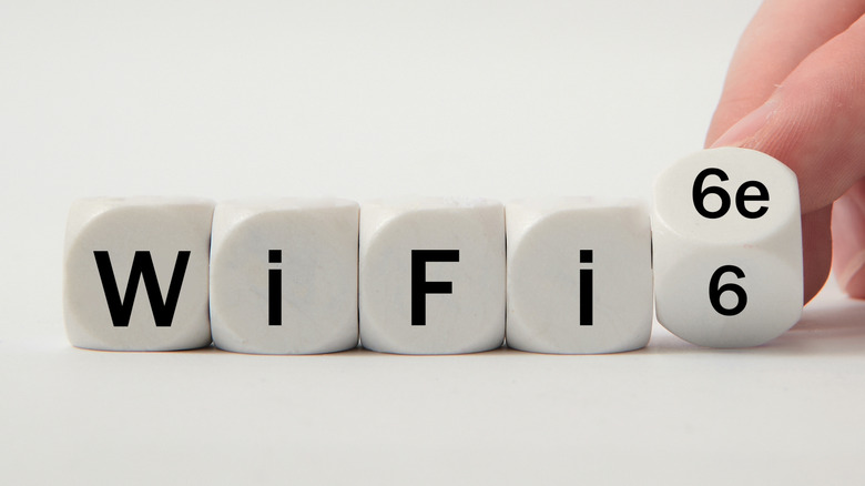 Five similarly sized cubes with letters on them. The first four spell out Wi-Fi whereas the last one is rotating, switching from the number 6 to 6E