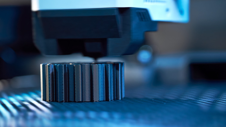 Close up of a 3D printer forming a small modular object.