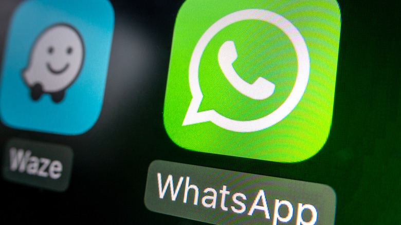 In this photo illustration a car's Apple CarPlay screen displays the logo of Meta's instant messaging service WhatsApp