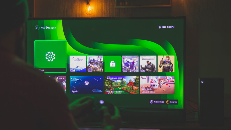 a person using the Xbox series X showing the operating system displayed on a smart TV
