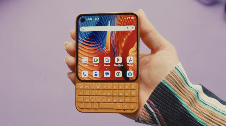 A person holding Unihertz's Titan 2 Elite smartphone featuring a BlackBerry-style physical keyboard.