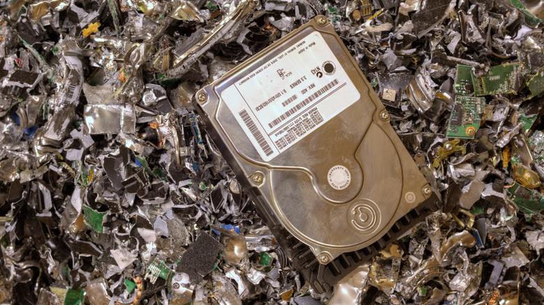 A hard drive sitting atop a pile of other shredded hard drives