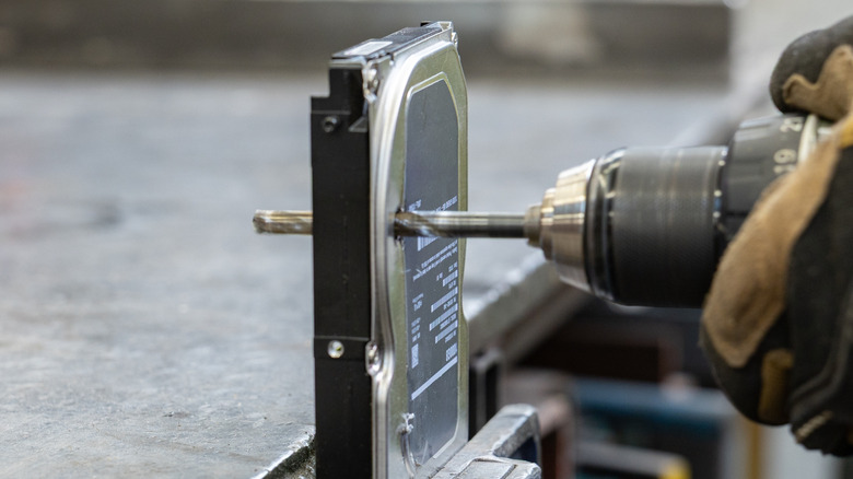 A person drilling through a hard drive