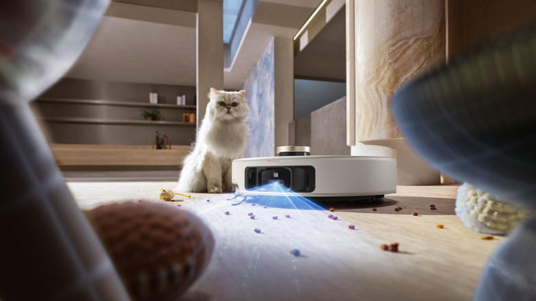 MOVA V50 Ultra Complete robot vacuum cleaning up cat food with cat watching