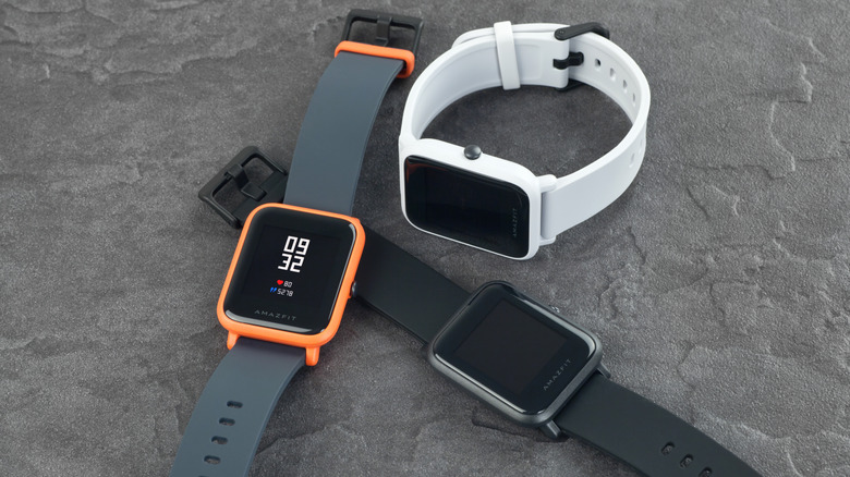 Three Amazfit Bip smartwatches against a gray background.