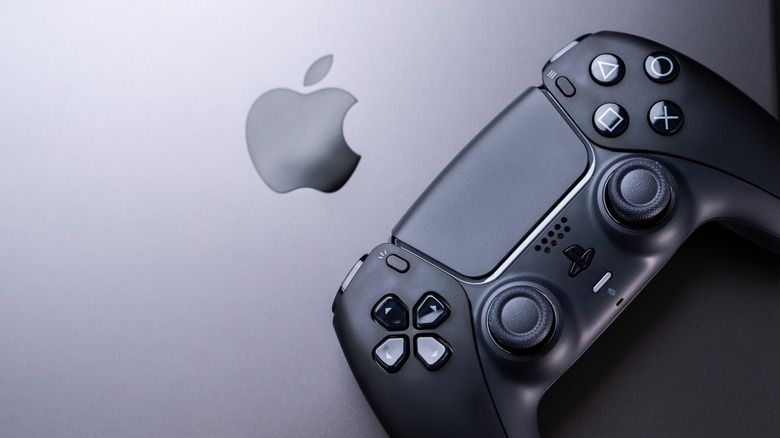 PlayStation 5 controller sitting on top of an Apple MacBook