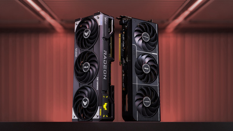 ASUS-branded RX 9070 and RX 9070 XT graphics cards standing next to each other on a flat surface.