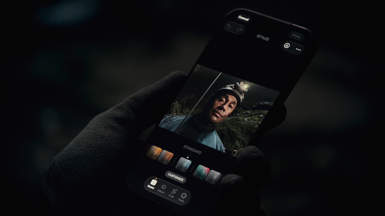 Hand holding an iPhone 18 Pro with the camera app open.