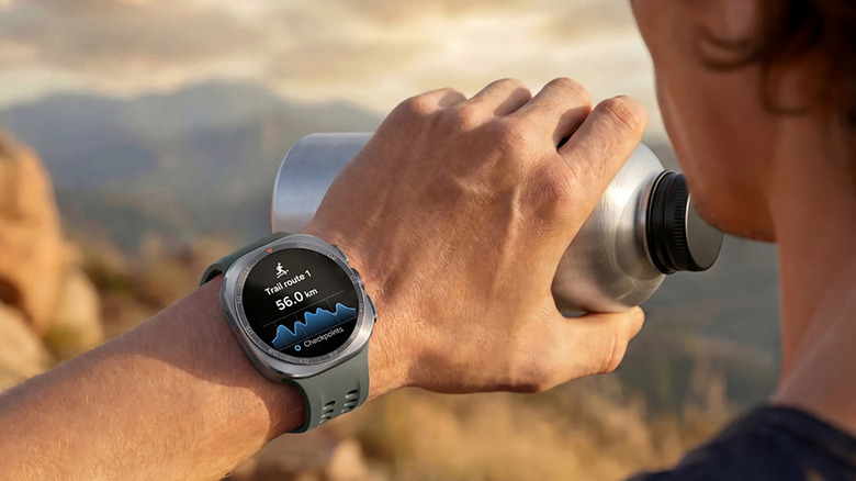 A man on a trail drinking from a water bottle while wearing the Samsung Galaxy Watch Ultra 2