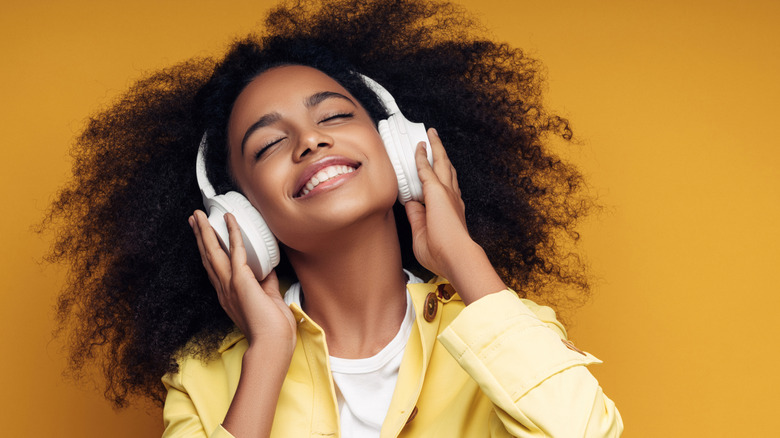 A woman listening to music on a pair of headphones.